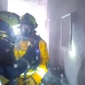 Bomberos en el interior del edificio de Elche en el que se ha registrado el incendio. Bomberos en el interior del edificio de Elche en el que se ha registrado el incendio.