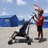 22 de mayo de 2026, Beirut, Líbano: Un niño desplazado tira de un pequeño carro en el que transporta a su hermana menor entre las filas de tiendas de campaña azules instaladas por el Gobierno libanés para acoger a las familias desplazadas de Beirut.