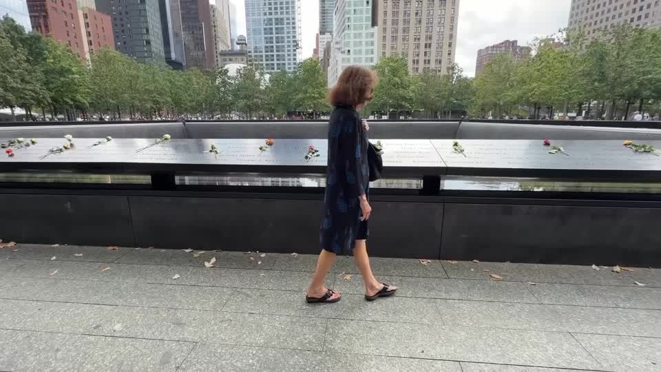 Una mujer pasea junto al muro y estanque conmemorativo por las víctimas del 11-S en Nueva York Una mujer pasea junto al muro y estanque conmemorativo por las víctimas del 11-S en Nueva York