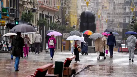 Paseantes y turistas se protegen de la lluvia en el centro de Oviedo, Asturias. Paseantes y turistas se protegen de la lluvia en el centro de Oviedo, Asturias.