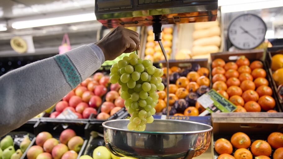 Un dependiente pesa un racimo de uvas en un mercado, a 31 de diciembre de 2023, en Madrid (Espa&ntilde;a).