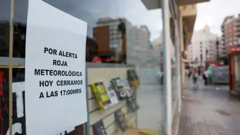 Detalle de un cartel avisando del cierre del comercio por la alerta roja por lluvias. Detalle de un cartel avisando del cierre del comercio por la alerta roja por lluvias.