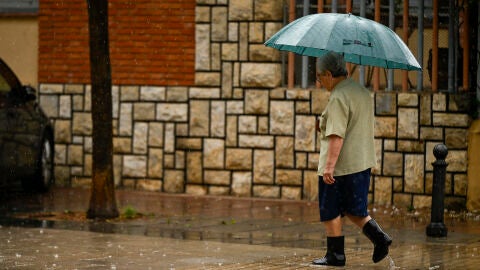 Una persona se protege de la lluvia con un paraguas