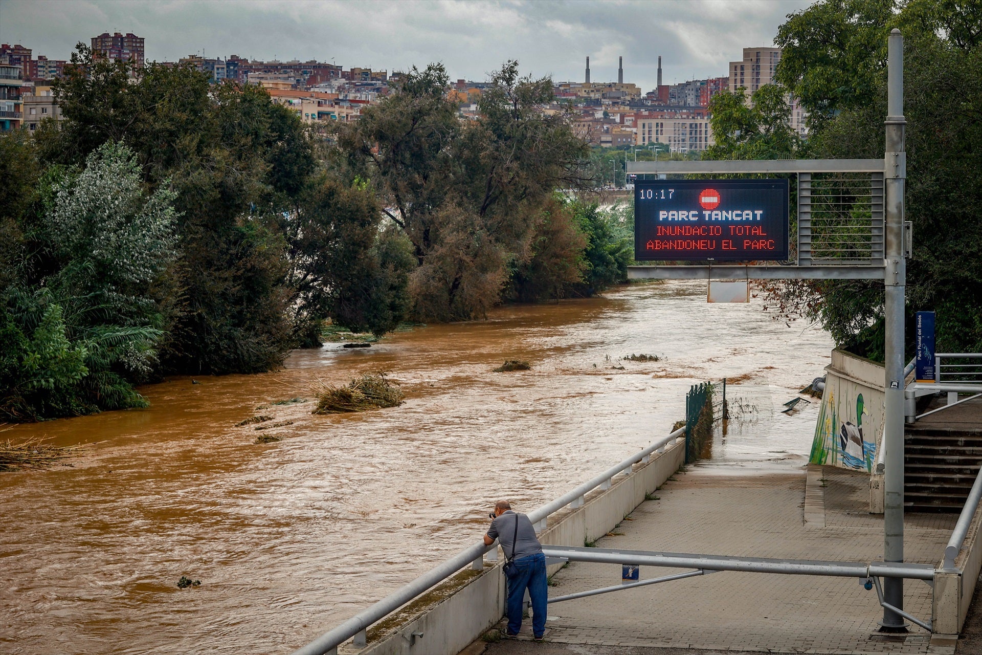 Una persona observa la crecida del río Besòs a causa de las lluvias torrenciales en Santa Coloma de Gramenet Una persona observa la crecida del río Besòs a causa de las lluvias torrenciales en Santa Coloma de Gramenet