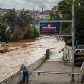 Una persona observa la crecida del río Besòs a causa de las lluvias torrenciales en Santa Coloma de Gramenet