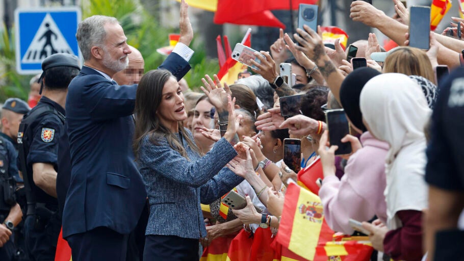 El rey Felipe VI (i, atr&aacute;s) y la reina Letizia (c) saludan a la multitud que espera su llegada ante el Ayuntamiento de CEuta, este martes. 