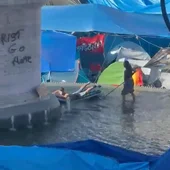 Los acampados de Sol utilizan la fuente de la estatua de Carlos III como piscina para bañarse con colchonetas Los acampados de Sol utilizan la fuente de la estatua de Carlos III como piscina para bañarse con colchonetas
