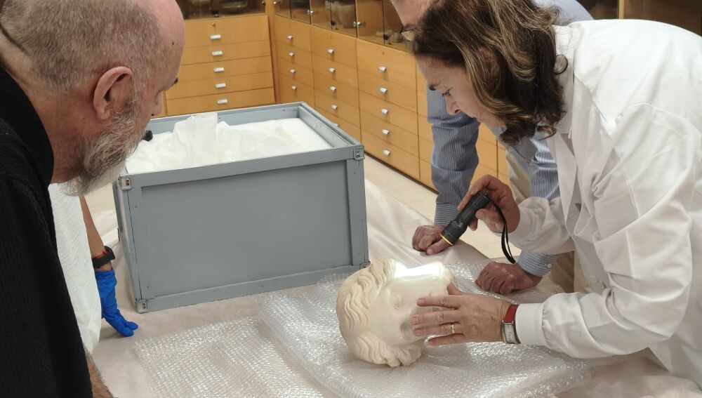 María Pilar Lapuente examina la escultura 