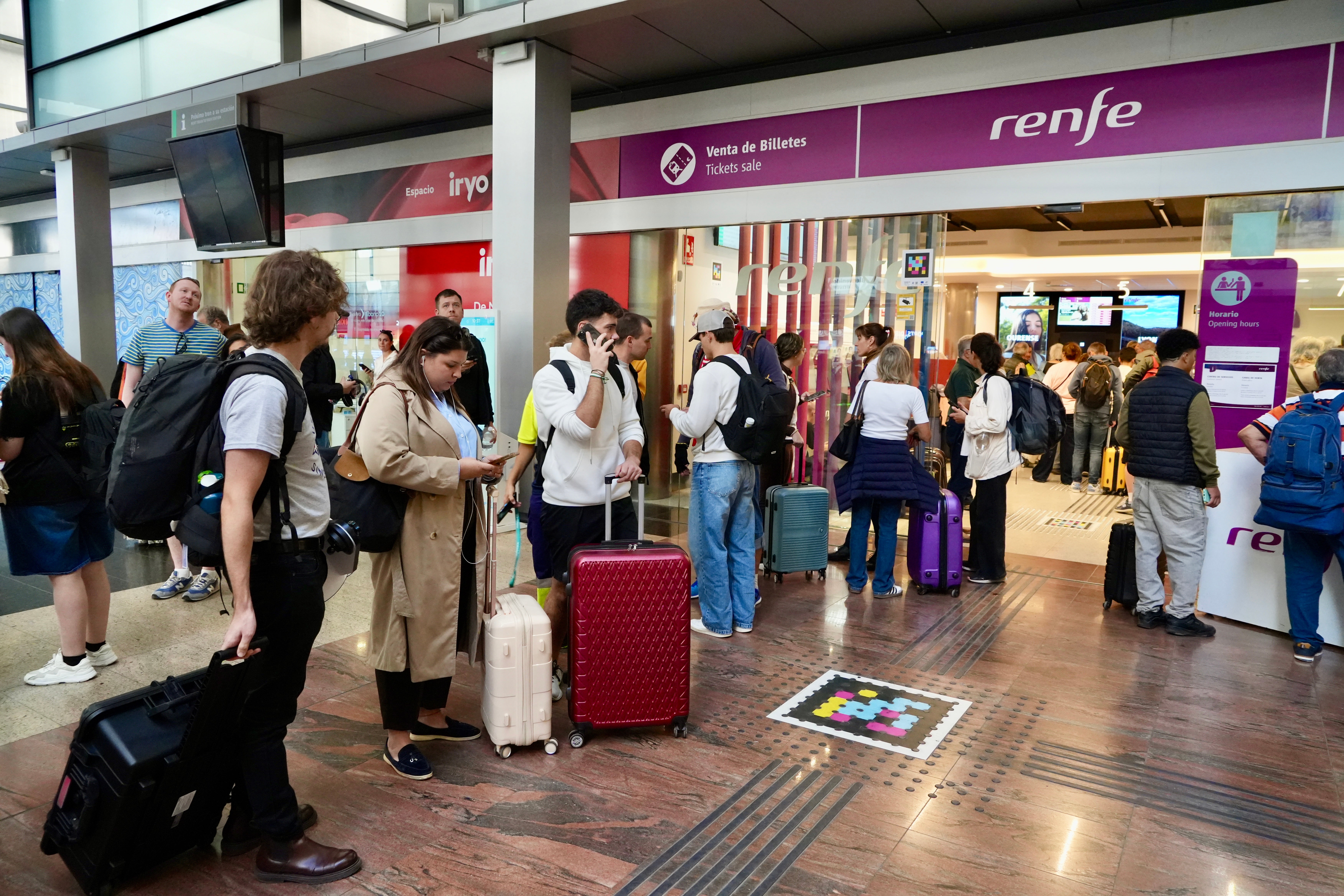 Varios pasajeros haciendo cola frente a Renfe para cancelar sus billetes Varios pasajeros haciendo cola frente a Renfe para cancelar sus billetes